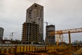 A large modern construction site in the construction of buildings and houses with appliances and many large high tower Royalty Free Stock Photo