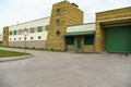 A large modern garage made of beige brick and green roller gates. Video surveillance system at the entrance to the garage. Safe Royalty Free Stock Photo