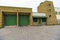 A large modern garage made of beige brick and green roller gates. Video surveillance system at the entrance to the garage. Safe Royalty Free Stock Photo