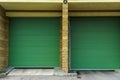 A large modern garage made of beige brick and green roller gates. Video surveillance system at the entrance to the garage. Safe Royalty Free Stock Photo