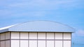 Large modern Industrial Building with Curved Aluminium Steel Roof against pale blue sky background Royalty Free Stock Photo