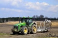 A large modern John Deere tractor tows a cultivator in a field