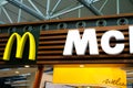 large modern signboard, McDonald\'s logo in lobby of airport, beautiful geometric background, three-dimensional letters