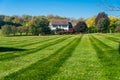 Large modern single family home with large green lawn and shrubs. Country two-story house. Landscape on an autumn sunny day Royalty Free Stock Photo