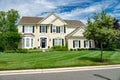 Large modern single family home with large lawn and beautiful landscaping. Sunny day with blue sky Royalty Free Stock Photo