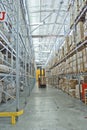 Large modern warehouse with forklifts, shelves with pallets, boxes, containers and goods