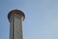 A large mosqoe tower with a blue sky behind it