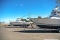 Large motor boats on car trailers parked at the pier