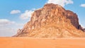 Large mountain in red desert, small 4wd vehicle in foreground for scale - typical scenery of Wadi Rum, Jordan Royalty Free Stock Photo