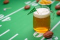 Large glass mug of cold beer on table with superbowl party decor