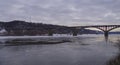 A large multi-span arch bridge over a frozen river. Landscape with a long arched bridge.