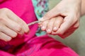 Large nails on the hand of the child. Mom cuts the baby`s nails with little baby scissors. Care and guardianship of children by