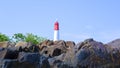 Large Natural Rocks Set Against The Lighthouse Tower Of Tanjung Kalian