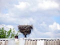 A large nest of storks on the roof of the house.