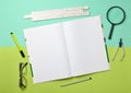 A large notebook for notes and drafting with stationery objects for a student on a green blue pastel background. Royalty Free Stock Photo