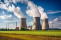 Large nuclear power plant with cooling towers emitting steam, producing energy in a rural landscape Royalty Free Stock Photo