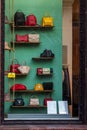 A large number of bags of different colors and sizes are presented for sale in the shop window.