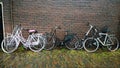 large number of beautiful modern fashion Bicycle leaning against the brick wall of a house on a city street Royalty Free Stock Photo