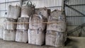 A large number of large bigbag poly sacks of industrail waste are stacked 3 layers