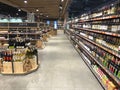 A large number of bottles of wine lying in a showcase in a supermarket