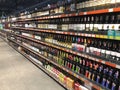 A large number of bottles of wine lying in a showcase in a supermarket