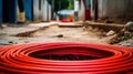 Large number of electric and high-speed Internet Network cables in red corrugated pipe on the street covered with