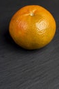 a large number of orange citrus fruits on a black slate surface Royalty Free Stock Photo