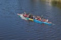 A large number of people are sailing on two very long sports rowing boats.