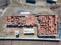 A large number of red bricks stacked on pallets near the construction site in the open air, enclosed by a fence, on a clear sunny Royalty Free Stock Photo