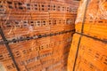A large number of red bricks are stacked together in a construction site, intended for renovation and major improvements of the