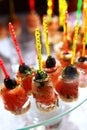 A large number of red fish canapes with cucumber and olives. Catering services for events. Field service. Photo on a dark