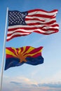 Large official Flag of US with smaller flag of Arizona state, Usa at cloudy sky background. United states of America patriotic