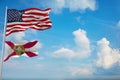 Large official Flag of US with smaller flag of Florida state, Usa at cloudy sky background. United states of America patriotic