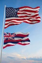 Large official Flag of US with smaller flag of Hawaii state, Usa at cloudy sky background. United states of America patriotic