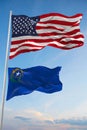 Large official Flag of US with smaller flag of Nevada state, Usa at cloudy sky background. United states of America patriotic