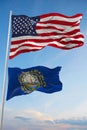 Large official Flag of US with smaller flag of New Hampshire state, Usa at cloudy sky background. United states of America