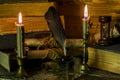 Large old books, scroll documents, a glass inkwell, burning candles stand on a table Royalty Free Stock Photo
