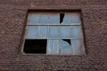 A large old broken window on a brown brick wall Royalty Free Stock Photo