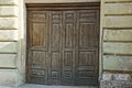 Large old brown wooden door on the concrete wall of the building Royalty Free Stock Photo