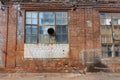 A large old dilapidated house of red and white bricks with large dilapidated windows. Old dirty abandoned factory building Royalty Free Stock Photo