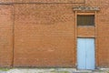 Large old dilapidated red brick house with a gray metal door. Old factory building Royalty Free Stock Photo