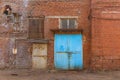 A large old dilapidated red brick house with large metal doors. Old dirty abandoned factory building Royalty Free Stock Photo