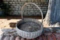 Large old round wicker basket with curved handle, courtyard of monastery