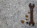 Large old rusty wrench and rusty bolts, nuts and washers lie on a gray mottled stone surface Royalty Free Stock Photo