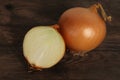 Large onion whole and cut on a wooden table, concept of vegetables for health against colds, horizontal, closeup, copy space