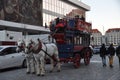 Large open top bus for tourists. Horse carriage along the street.