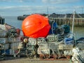 Large orange buoy on fishing canisters in Whitstable harbour Royalty Free Stock Photo