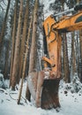 Large orange excavator bucket covered with snow in winter forest. Vertical orientation Royalty Free Stock Photo