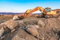 A large orange excavator moving stone in a quarry Royalty Free Stock Photo