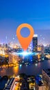 Large orange map pin icon over vibrant smart city at night with digital network connectivity Royalty Free Stock Photo